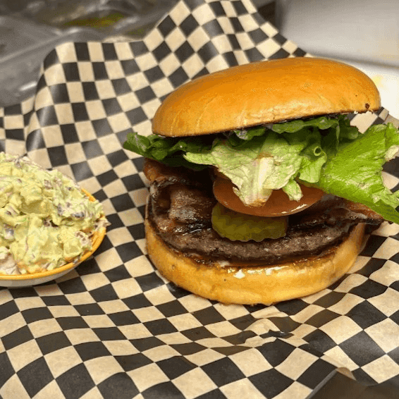 Cheeseburger topped with melted American cheese on a sesame bun