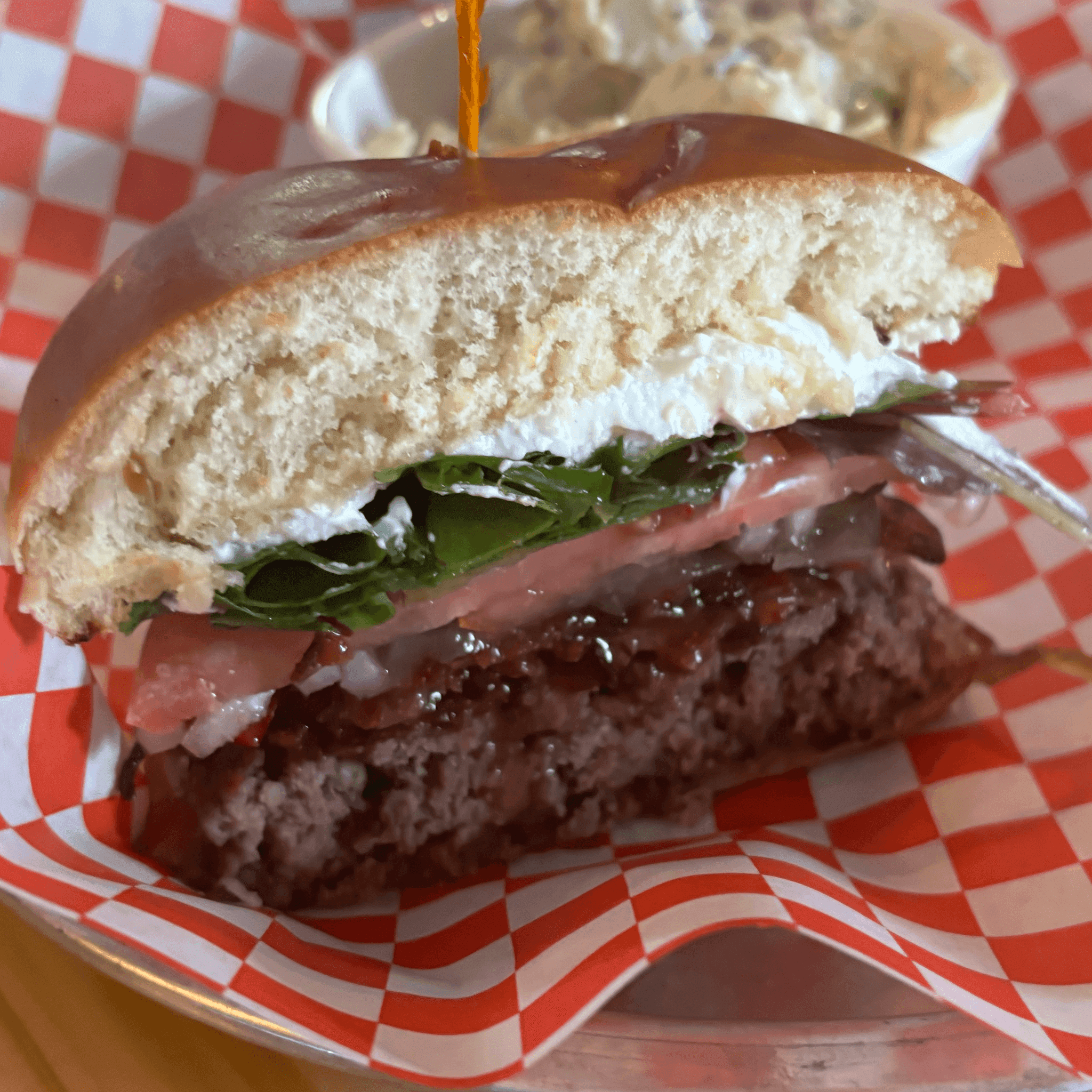 Burger with goat cheese, fresh greens and red onion on a soft bun